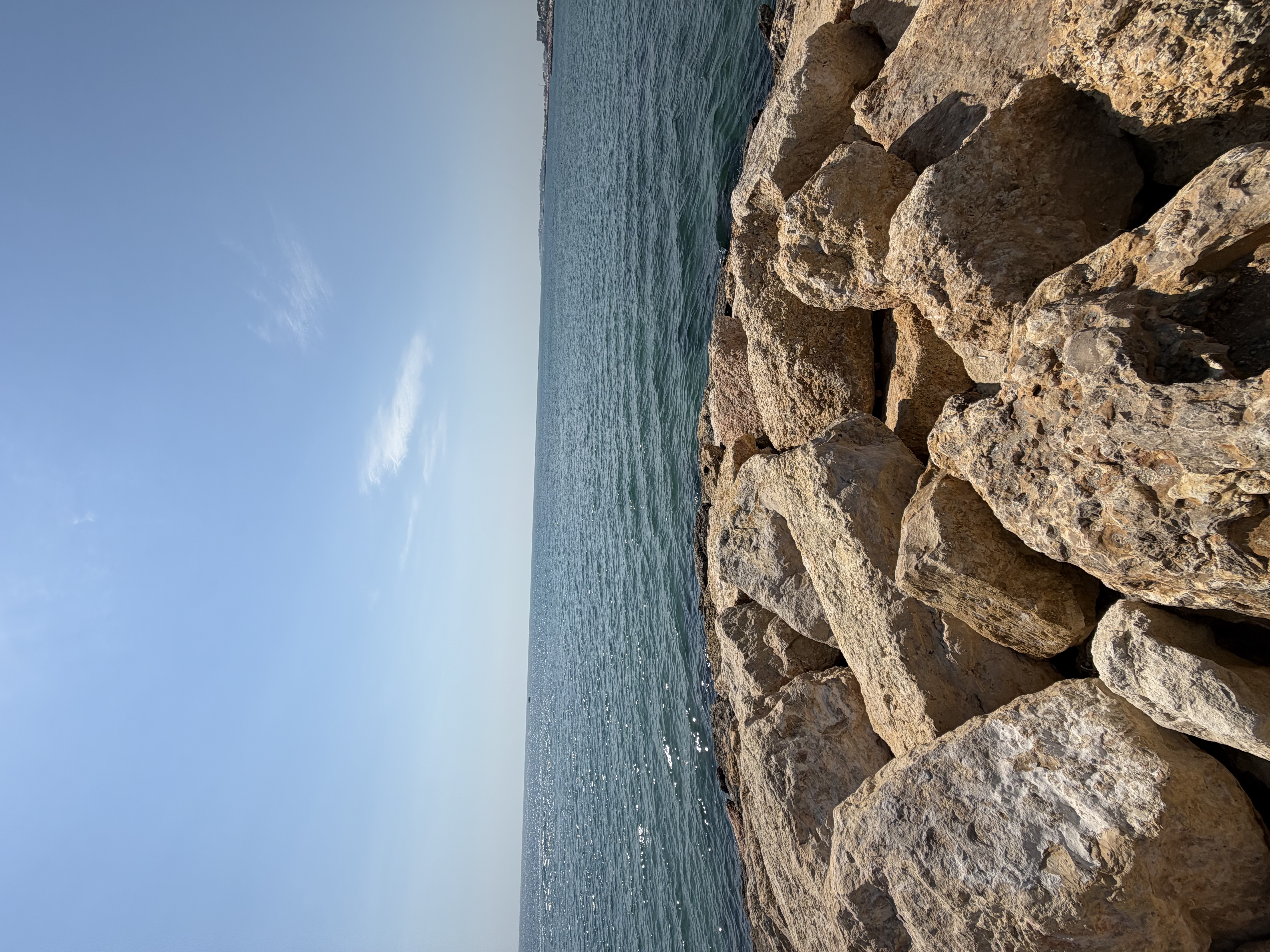 Pale rocks in the foreground, blue sea behind them