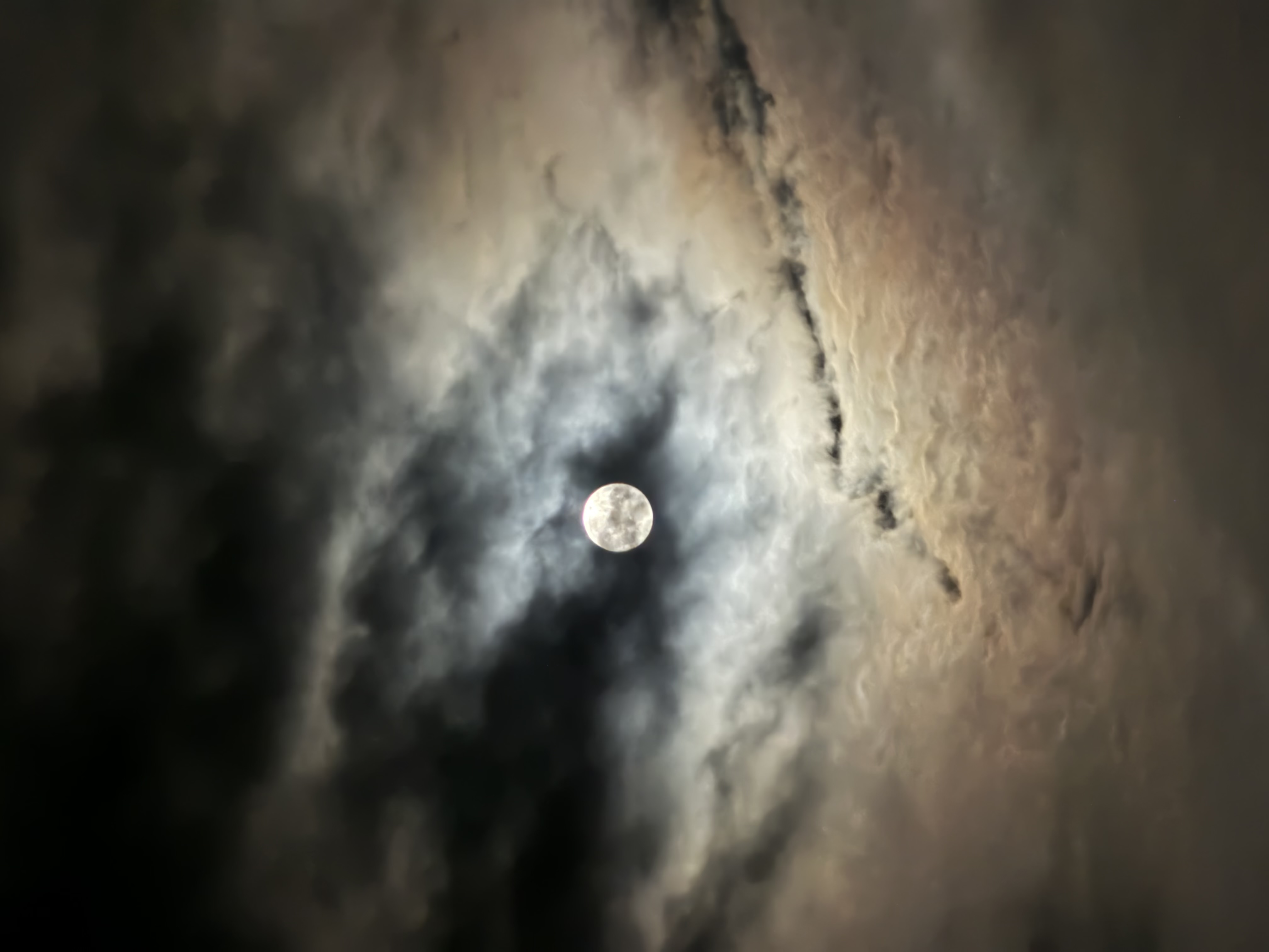 The moon seen through a hole in thin clouds