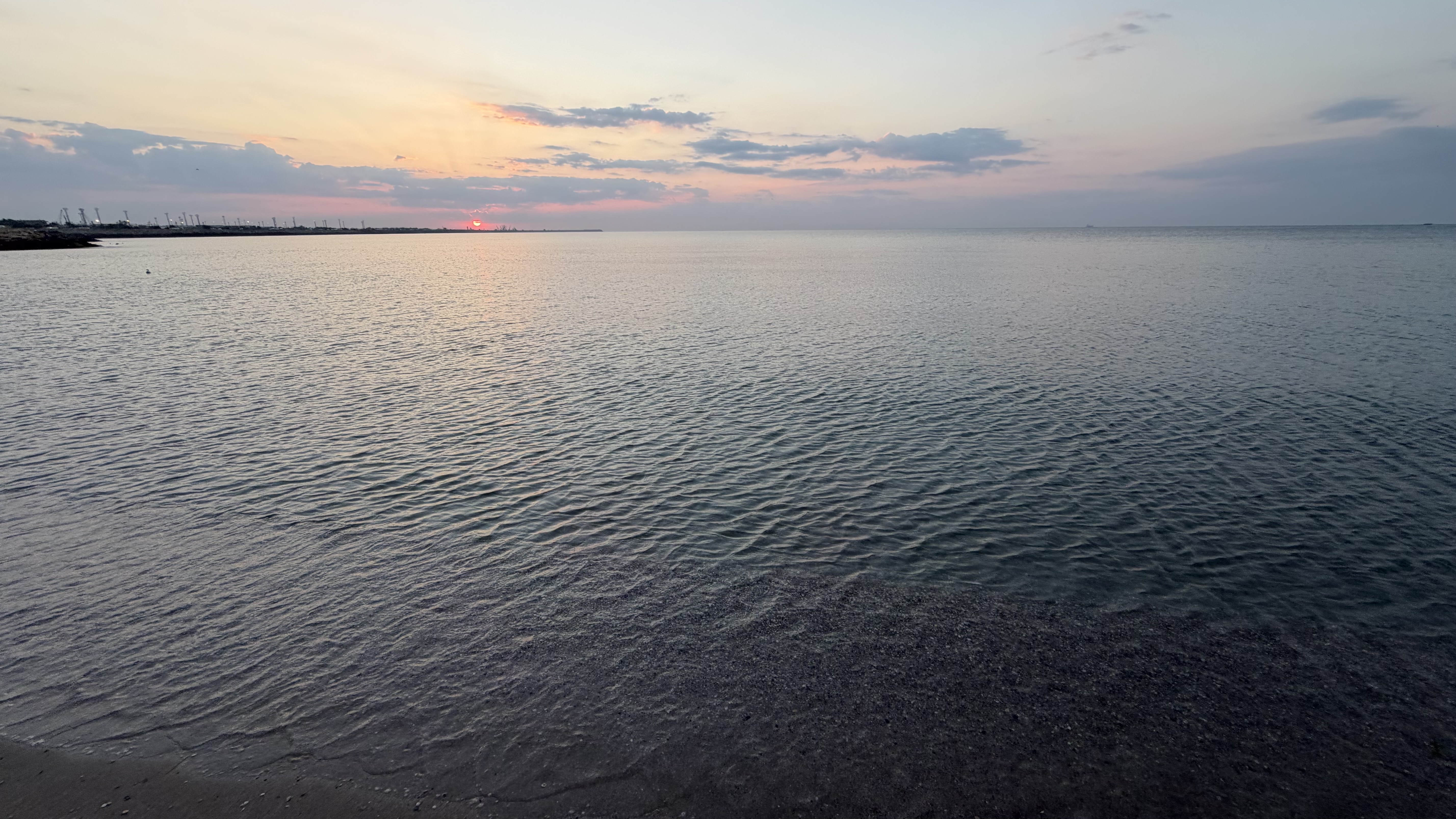 Wide view of a quiet sea at sunset