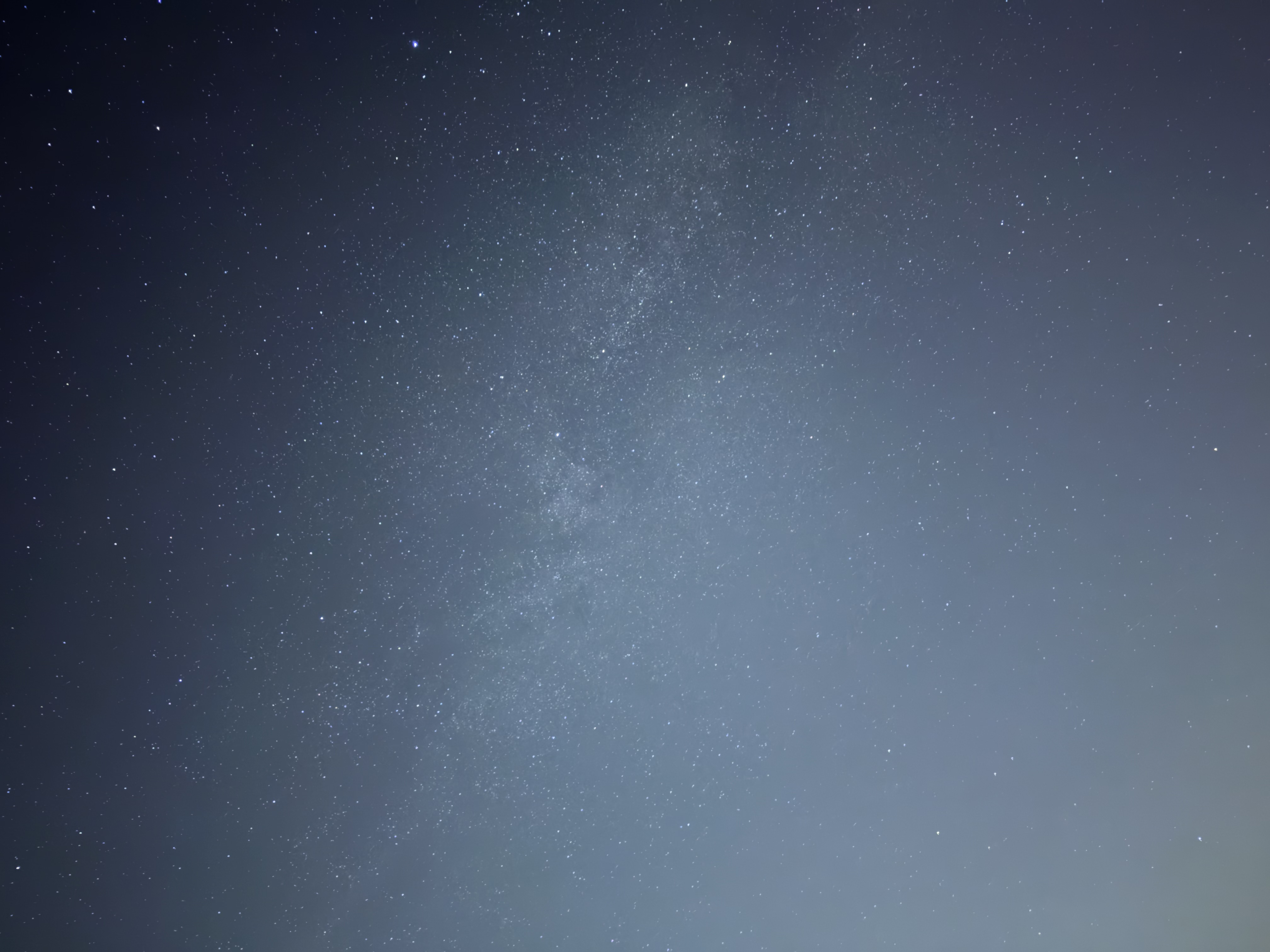 A faint band of stars in a hazy night sky