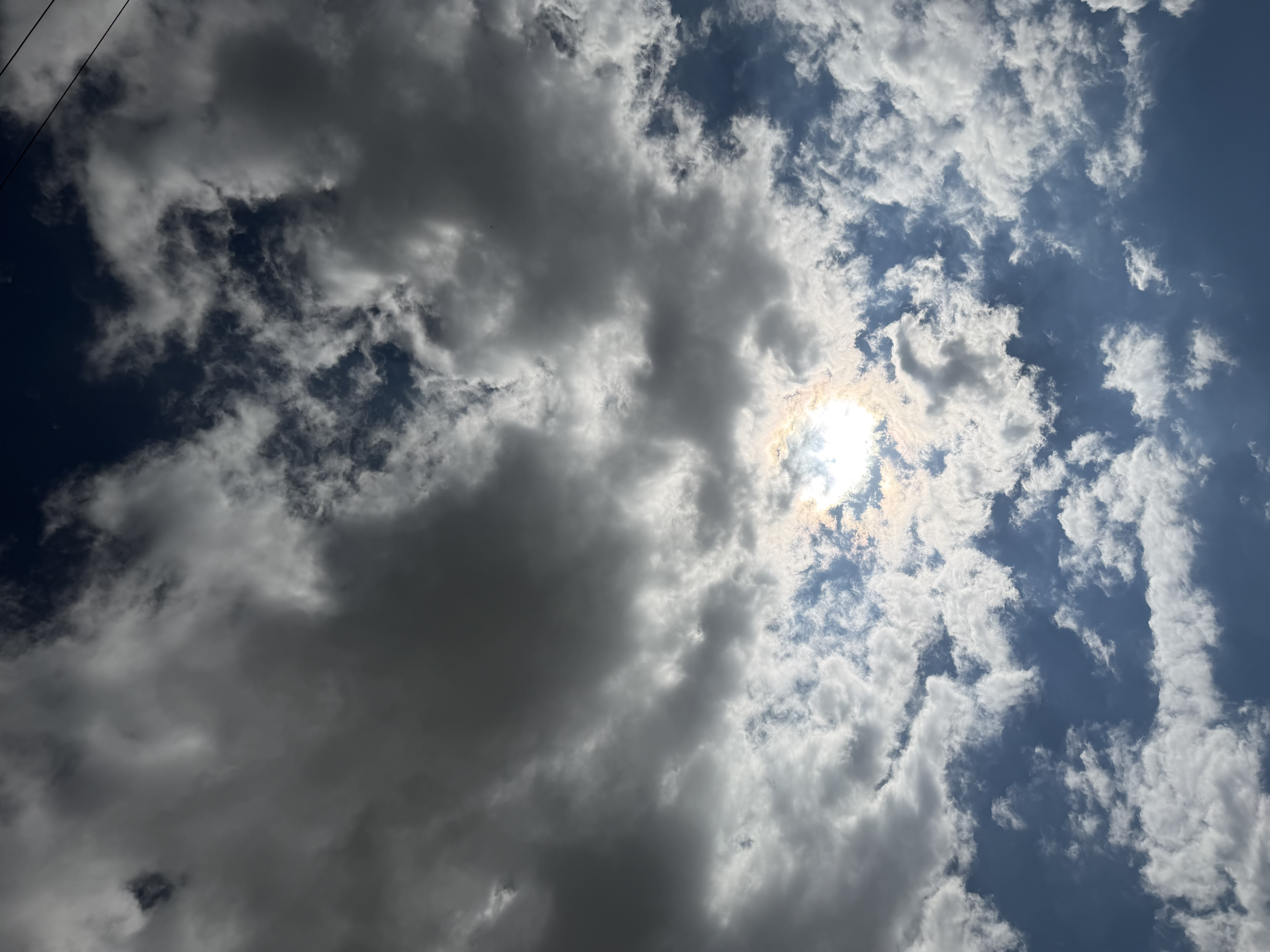 The sun behind bright clouds, shot looking straight up